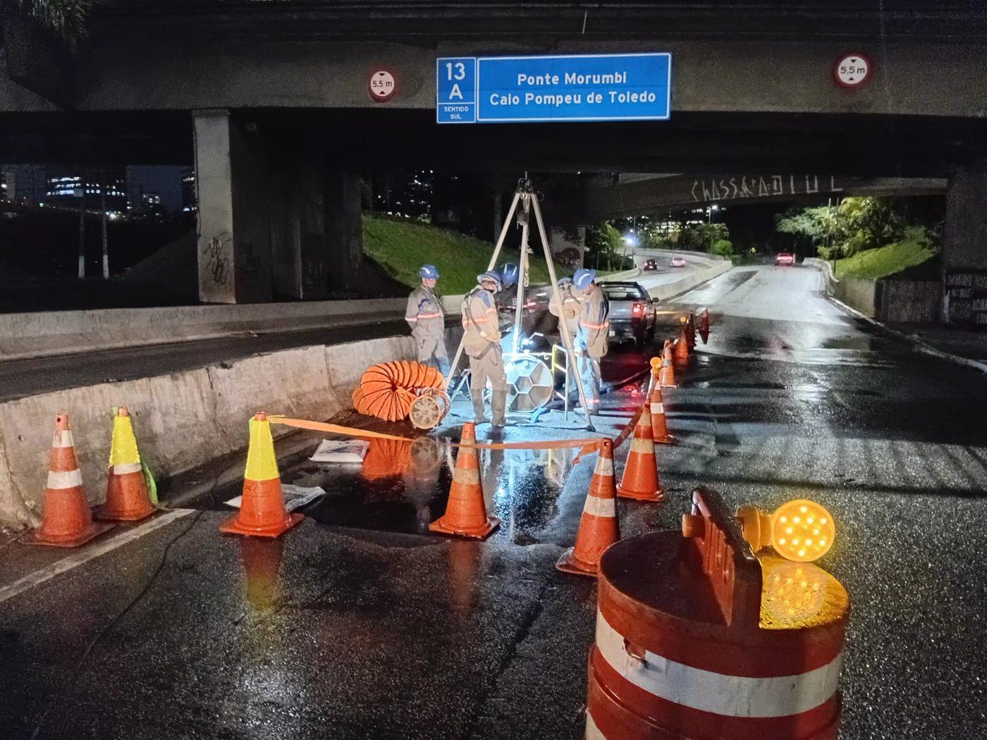 Equipe da DRC em obra noturna sob viaduto em São Paulo, com sinalização completa e trânsito fluindo